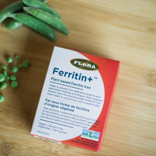 Flora Ferritin+ in 30 vegan capsules package on a table right next to peas